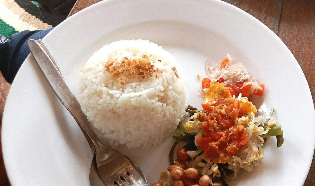 A white plate of rice and beans, representing affordable food in Bali restaurants